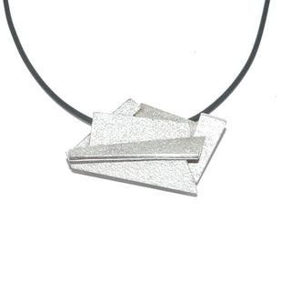 Handarbeit wandelbarer Unikat-Anhänger aus massiv 925 Silber, in variablen Positionen tragbar, ca. 32 mm x 20 mm, 4 verdeckte Schlaufen, besondere Oberflächenstruktur und polierten Kanten, in mehreren Ebenen geometrische Flächen verbunden, dreidimensional. Dazu paßt - Unikatschmuck nur erhältlich im Onlineshop von Juwelier & Goldschmiede Danilo! 