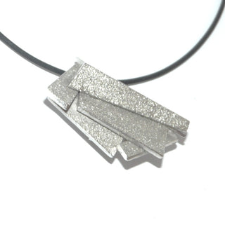 Handarbeit wandelbarer Unikat-Anhänger aus massiv 925 Silber, in variablen Positionen tragbar, ca. 32 mm x 20 mm, 4 verdeckte Schlaufen, besondere Oberflächenstruktur und polierten Kanten, in mehreren Ebenen geometrische Flächen verbunden, dreidimensional. Dazu paßt - Unikatschmuck nur erhältlich im Onlineshop von Juwelier & Goldschmiede Danilo! 