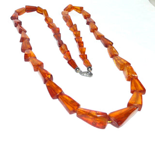 Handgeschliffenes Einzelstück aus dem Art Deco, Vintage-Bernstein-Kette aus polierten flachen Triangeln / Trapeze mit schönen dezenten Einschlüssen, Verlauf, ungeknotet aufgefädelt, mittleres Cognac-orange, mit einem Verschluß aus Silber, Gesamtlänge 70 cm, Art Deco um 1930 - Vintage-Schmuck nur im Onlineshop von danilogold!