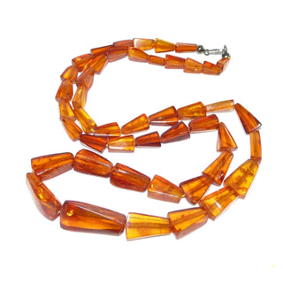 Handgeschliffenes Einzelstück aus dem Art Deco, Vintage-Bernstein-Kette aus polierten flachen Triangeln mit schönen Einschlüssen, Verlauf ungeknotet aufgefädelt, mittleres Cognac-orange, mit einem Verschluß aus Silber, Gesamtlänge 70 cm, um 1920 - Vintage-Schmuck nur im Onlineshop von danilogold!