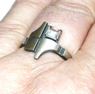 Einzelstück, Nordform-Design, Nordform-Ring "Geometrik" aus 925 Silber, mit einem funkelnd facettierten, quadratischen Bergkristall, seidenmatt, in den Tiefen geschwärzt, verstellbare Ringweite bis ca. 68. Anlaufgeschützt. Die gesamte skandinavische / finnische Nordform-Kollektion ist so designt, daß fast alle Schmuckstücke miteinander kombinierbar sind. Besonders gut zu diesem Schmuckstück Halsschmuck Nord 0006. -	skandinavisches Design zuhause bei www.danilogold-shop.de