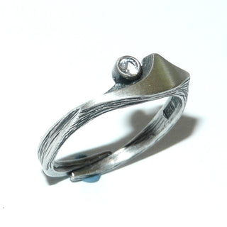 Rest-Paar, Bergkristall-Ring Nordform-Design "Kleiner Schweif" aus 925 Silber, mit einem funkelnd facettierten, runden Bergkristall, seidenmatt, in den Tiefen geschwärzt, verstellbare Ringweite bis ca. 62. Anlaufgeschützt. Die gesamte skandinavische / finnische Nordform-Kollektion ist so designt, daß fast alle Schmuckstücke miteinander kombinierbar sind. Besonders gut zu diesem Schmuckstück paßt Anhänger Nord 0018 + Ohrstecker Nord 0064-	skandinavisches Design zuhause bei www.danilogold-shop.de