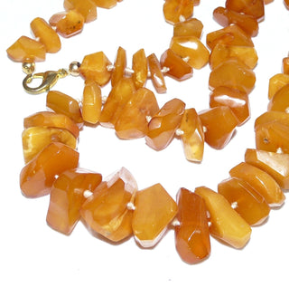 handgeschliffenes Einzelstück, Vintage-Bernstein-Kette aus polierten, großen, flachen, sparsam facettierten Chips / Splittern im Verlauf durchgeknotet, honigfarbener Butterscotch, Karabiner-Verschluß aus Gold-Doublé, Gesamtlänge 72 cm, Art Deco um 1930
- Vintage-Schmuck nur im Onlineshop von danilogold!
