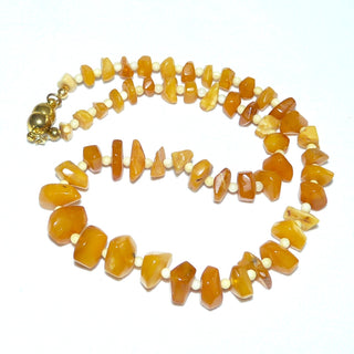 handgefertigtes Einzelstück, Bernstein-Kette aus polierten, sparsam facettierten, flachen Nuggets in einem hellen Gelb-orange, ungeknotet im Verlauf aufgereiht, dazwischen beigefarbene Kugeln, moderner praktischer Magnet-Verschluß aus Gold-Doublé, der sich von selbst schließt, Gesamtlänge 41,5 cm -	Handarbeiten online bestellen bei Juwelier & Goldschmiede Danilo!