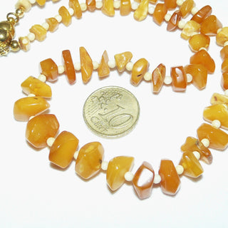 handgefertigtes Einzelstück, Bernstein-Kette aus polierten, sparsam facettierten, flachen Nuggets in einem hellen Gelb-orange, ungeknotet im Verlauf aufgereiht, dazwischen beigefarbene Kugeln, moderner praktischer Magnet-Verschluß aus Gold-Doublé, der sich von selbst schließt, Gesamtlänge 41,5 cm -	Handarbeiten online bestellen bei Juwelier & Goldschmiede Danilo!