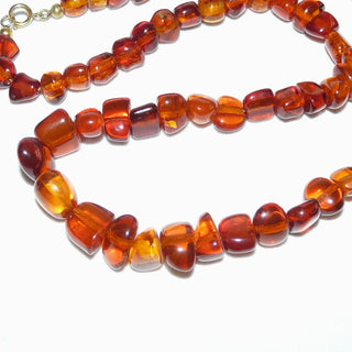 handgeschliffenes Einzelstück, Bernstein-Kette aus polierten, unregelmäßige, Nuggets im Verlauf ungeknotet aufgereiht, mit dezenten Einschlüsse in dunklerem Cognac-orange, Verschluß aus Gold-Doublé, Gesamtlänge 50 cm -	Unikatschmuck nur erhältlich im Onlineshop von Juwelier & Goldschmiede Danilo! 