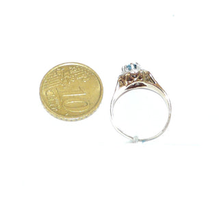 ovales Einzelstück, Blautopasring aus 375 Gold, eine ovale Rosette aus 8 Herzen mit je einem Diamant im Pavé gefaßt, in den Tiefen rhodiniert, ein ovaler, facettierter, aquamarin-hellblauer Edeltopas mit 8 Krappen gehalten, floral gravierte Seitenflächen / Seitenteile & poliert, Ringweite 57 - Goldschmiede Danilo