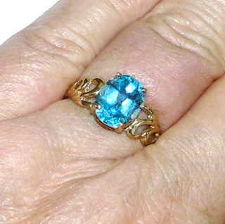 Durchbrochenes Einzelstück, Blautopasring, Solitär, durchbrochene florale Schlaufen in der Ringschiene, aus 375 Gold mit einem funkelnd facettierten, dunkel aquamarinblauen, ovalen Edeltopas in Krappen gefaßt, poliert, Ringweite 57 - Goldschmiede Danilo