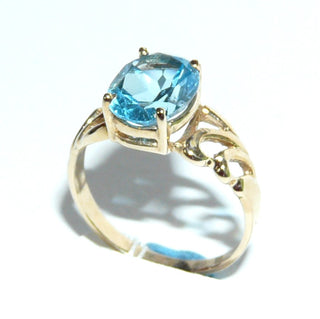Durchbrochenes Einzelstück, Blautopasring, Solitär, durchbrochene florale Schlaufen in der Ringschiene, aus 375 Gold mit einem funkelnd facettierten, dunkel aquamarinblauen, ovalen Edeltopas in Krappen gefaßt, poliert, Ringweite 57 - Goldschmiede Danilo