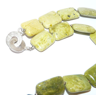 Einzelstück, handgefädelte Edelsteinkette, zitronengelb-grüne flache Kissen im Farbverlauf aus Chita-Jade / Werdit mit dunklen Einschlüssen aus Chromit, Schnecke, Mini-Kügelchen & runder Einhaker-Verschluß aus 925 Silber, Länge 46,5cm, flexibel aufgefädelt auf Stahlseide - Goldschmiede Danilo