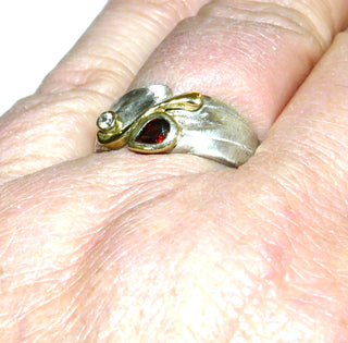 Einzelstück, Unikat-Granat-Ring mit einem asymmetrischen Oberteil aus 925 Silber. Bogen + Zargenfassung vergoldet, mit einem tropfenförmigen, funkelnd facettierten Granat in schöner roter Farbe + einem runden Zirkonia als Brillant-Replik, Ringweite 57