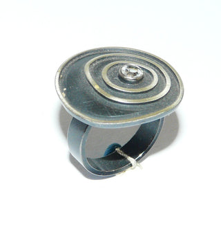 Einzelstück, Lorena-Design, schwarzer Ring "Konzentrik groß" aus 925 Silber, mit einem runden, funkelnd facettierten Bergkristall, seidenmatt, in den Tiefen geschwärzt, asymmetrische konzentrische Kreise, Ringweite 53,5. Österreichischer Design-Schmuck -	
Nur erhältlich im Onlineshop von Juwelier & Goldschmiede Danilo!
