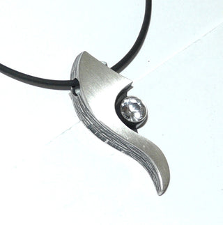 Einzelstück, Nordform-Design, Anhänger "langer Schweif" aus 925 Silber mit einem runden, funkelnd facettierten Bergkristall, seidenmatt, in den Tiefen geschwärzt, zum Durchfädeln. Anlaufgeschützt. Die gesamte skandinavische / finnische Nordform-Kollektion ist so designt, daß fast alle Schmuckstücke miteinander kombinierbar sind. Besonders gut zu diesem Schmuckstück paßt Ring Nord 0032, Ohrschmuck Nord 0064, 0065 + 0066. (Lieferung erfolgt ohne Kette) -	Finnlandschmuck bei Goldschmiede Danilo