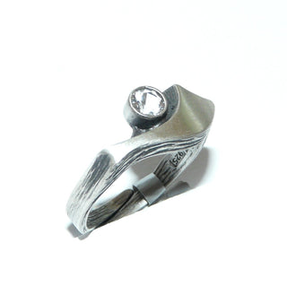 Einzelstück, Nordform-Design, Nordform-Ring "großer Schweif" aus 925 Silber mit einem runden, funkelnd facettierten Bergkristall, seidenmatt, in den Tiefen geschwärzt, verstellbare Ringweite bis ca. 62. Anlaufgeschützt. Die gesamte skandinavische / finnische Nordform-Kollektion ist so designt, daß fast alle Schmuckstücke miteinander kombinierbar sind. Besonders gut zu diesem Schmuckstück paßt der Anhänger Nord 0018 + den Ohrringen Nord 0065, 0066 -	Finnlandschmuck bei Goldschmiede Danilo