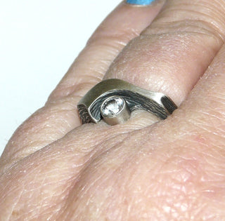 Einzelstück, Nordform-Design, Nordform-Ring "großer Schweif" aus 925 Silber mit einem runden, funkelnd facettierten Bergkristall, seidenmatt, in den Tiefen geschwärzt, verstellbare Ringweite bis ca. 62. Anlaufgeschützt. Die gesamte skandinavische / finnische Nordform-Kollektion ist so designt, daß fast alle Schmuckstücke miteinander kombinierbar sind. Besonders gut zu diesem Schmuckstück paßt der Anhänger Nord 0018 + den Ohrringen Nord 0065, 0066 -	Finnlandschmuck bei Goldschmiede Danilo