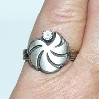 Einzelstück, Nordform-Design-Ring "Sonnenrad" aus 925 Silber mit einem runden, funkelnd facettierten Bergkristall, seidenmatt, in den Tiefen geschwärzt, verstellbare Ringweite bis ca. 65. Anlaufgeschützt. Die gesamte skandinavische / finnische Nordform-Kollektion ist so designt, daß fast alle Schmuckstücke miteinander kombinierbar sind. Besonders gut zu diesem Schmuckstück paßt Nord 0023. -	Finnlandschmuck bei Goldschmiede Danilo