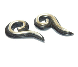 Einzelstücke, Ohrstecker "Seepferdchen" aus 925 Silber, poliertes geschwungenes Silber-Drahtornament, welches an die Seepferdchen-Haltung erinnert, befestigt auf einem dunkelbraunen, geschwungenen + poliertem Holz -	Nur erhältlich im Onlineshop von Juwelier & Goldschmiede Danilo!