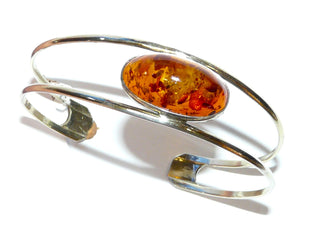 Retro-Einzelstück, Armreif, offene Armspange aus 835 Silber mit cognacfarbenem länglich-ovalen Bernstein in einer Zargenfassung, der Naturstein wird von 2 Silberstreben "eingespannt", Innenumfang ca. 18,5 cm, um 1950 Unikatschmuck nur erhältlich im Onlineshop von Juwelier & Goldschmiede Danilo! 
 