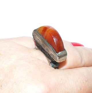 Erhabenes Einzelstück, ungewöhnlicher Vintage-Karneol-Ring aus 925 Silber, flacher Karneol aufrecht in Zarge gehalten, seitlich gravierte Bogenelemente, in den Tiefen geschwärzt, matt, seitliche Einlagen aus schwarzem Holz, Ringweite 59,5, um 1970 - Unikatschmuck nur erhältlich im Onlineshop Goldschmiede Danilo! 