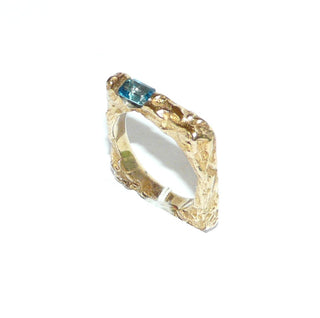 besonderes Einzelstück, handgefertigter Unikat-Blautopasring mit quadratischer Außenform, zerklüftete Oberfläche in massiv 333 Gold, ein funkelnd facettierter, dunkel aquamarinblauer Topas im Baguette-Schliff, von 2 Seiten gefaßt, eine Seitenfläche glatt & poliert, Ringweite 58 - Goldschmiede Danilo