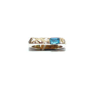besonderes Einzelstück, handgefertigter Unikat-Blautopasring mit quadratischer Außenform, zerklüftete Oberfläche in massiv 333 Gold, ein funkelnd facettierter, dunkel aquamarinblauer Topas im Baguette-Schliff, von 2 Seiten gefaßt, eine Seitenfläche glatt & poliert, Ringweite 58 - Goldschmiede Danilo