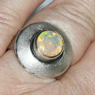 Handgearbeitetes Einzelstück, Unikat Opal-Ring "Konzentrik" aus 925 Silber mit einemrunden, blau-orange-grün schillernden, facettierten, äthiopischen Welo-Opal, mattiert mit polierten Akzenten + in den Tiefen geschwärzt, Ringweite verstellbar bis ca. 59
-	Handgefertigter Schmuck nur erhältlich bei www.danilogold-shop.de 