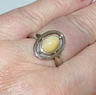 Handgefertigtes Einzelstück, Unikat-Ring aus massivem 585 Palladium-Weißgold mit einem grün-orange schillernden, äthiopischen, ovalen Welo-Opal, sicher eingefaßt in einer Zargenfassung, umrandet mit einem aus einem Runddraht geformten Oval, poliert, Ringweite 55,5 -	Handgefertigtes Unikat! Nur im Danilo Gold Online Shop!
