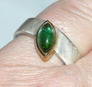 handgefertigtes Einzelstück, Unikat-Ring aus 925 Silber und einer Zargenfassung aus 900-er Gelbgold, asymmetrisch eingelassener flaschengrüner Turmalin-Cabochon in Navetteform mit schönen dezenten Einschlüssen, seidenmattierte Ringschiene, Ringweite 52 -	Handarbeiten online bestellen bei Juwelier & Goldschmiede Danilo!