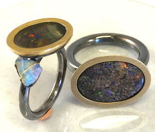 Handgearbeitetes Einzelstück, Unikat-Ring aus 925 Silber, oxidiert + 585 Gold, mit einem ovalen, in allen Farben herrlich schillernden, australischen Opal-Matrix-Cabochon "upside down" + einem Opal-Kristall, die aufgetiefte Schalenfassung hat einen goldenen, seidenmatten Zargenrand, Ringweite 54 (rutscht sehr gut über den Knöchel, weil Runddrahtschiene) -	Handgefertigtes Unikat! Nur im Onlineshop von Juwelier & Goldschmiede Danilo!