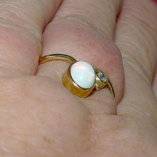Handgearbeitetes Einzelstück, Unikat-Ring aus 585 Gold mit einem herrlich in grün-rot schillernden, weißen kristallinen, australischen, ovalen Opal-Cabochon + 1 Brillanten von 0,03 Karat, sicher eingefaßt in Zargenfassungen, mit einer elegant geschwungenen, polierten Ringschiene, Ringweite 55 - Handarbeiten online bestellen bei Juwelier & Goldschmiede Danilo!