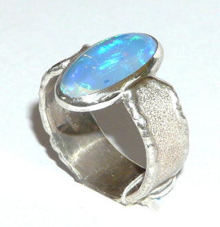 Handgefertigtes Einzelstück, Unikat, breiter Opal-Ring aus 925 Silber mit einem blau-grün schillernden, australischen Jelly-Opal als lang-ovaler Cabochon, strukturierte, mattgeschlagene, massive Ringschiene mit polierten Kanten, Ringweite ca. 62 -	Unikatschmuck nur erhältlich im Onlineshop von Juwelier & Goldschmiede Danilo! 