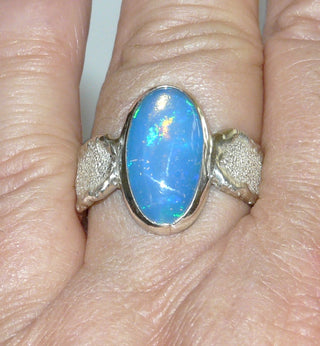 Handgefertigtes Einzelstück, Unikat, breiter Opal-Ring aus 925 Silber mit einem blau-grün schillernden, australischen Jelly-Opal als lang-ovaler Cabochon, strukturierte, mattgeschlagene, massive Ringschiene mit polierten Kanten, Ringweite ca. 62 -	Unikatschmuck nur erhältlich im Onlineshop von Juwelier & Goldschmiede Danilo! 