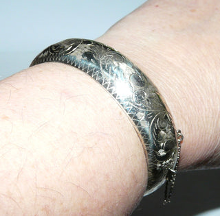 Einzelstück, Vintage-Armreif, Armspange aus 925 Silber mit Kastenschloß + Sicherheitskette, Oberfläche floral graviert, halbrunder Querschnitt, ganz leicht oval, 1,7 cm breit, leider hat er zwei kleine Dellen, die durch die Gravur aber nicht auffallen, Innenumfang 17,5 cm, um 1980  -	Einzelstücke nur erhältlich bei www.danilogold-shop.de