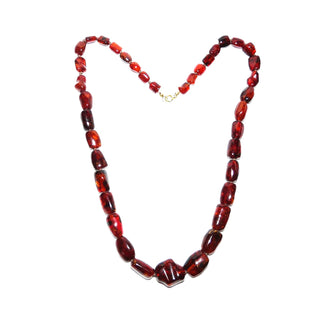 antikes Einzelstück, handgearbeitete Vintage-Bernstein-Kette aus polierten größeren Tönnchen im Verlauf mit einem Mittelstein, durchgeknotet, dunkleres Rotbraun mit schönen Einschlüssen, Verschluß aus Gold-Doublé, Gesamtlänge 60 cm, um 1950 -	Unikatschmuck nur erhältlich im Onlineshop von Juwelier & Goldschmiede Danilo! 