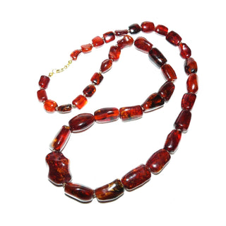 antikes Einzelstück, handgearbeitete Vintage-Bernstein-Kette aus polierten größeren Tönnchen im Verlauf mit einem Mittelstein, durchgeknotet, dunkleres Rotbraun mit schönen Einschlüssen, Verschluß aus Gold-Doublé, Gesamtlänge 60 cm, um 1950 -	Unikatschmuck nur erhältlich im Onlineshop von Juwelier & Goldschmiede Danilo! 