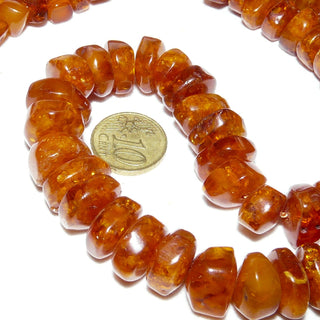 handgeschliffenes Einzelstück, Vintage-Bernstein-Kette aus polierten, sparsam facettierten, dicken Linse, im Verlauf ungeknotet aufgereiht, dunkleres Cognac-braun mit schönen Einschlüssen, Verschluß aus Gold-Doublé, Gesamtlänge 65 cm, um 1950 -	Handgefertigtes Unikat! Nur im Danilo Gold Online Shop!