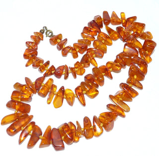 Handgeschliffenes Einzelstück, Vintage-Bernstein-Kette aus polierten, großen, länglichen Chips / Splittern, im Verlauf durchgeknotet, mittleres Cognac-orange, Verschluß aus Gold-Doublé, Gesamtlänge 56 cm, um 1950 -	Vintage-Schmuck nur im Onlineshop von danilogold!