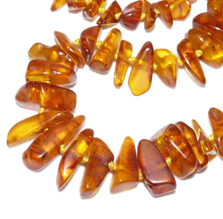 Handgeschliffenes Einzelstück, Vintage-Bernstein-Kette aus polierten, großen, länglichen Chips / Splittern, im Verlauf durchgeknotet, mittleres Cognac-orange, Verschluß aus Gold-Doublé, Gesamtlänge 56 cm, um 1950 -	Vintage-Schmuck nur im Onlineshop von danilogold!