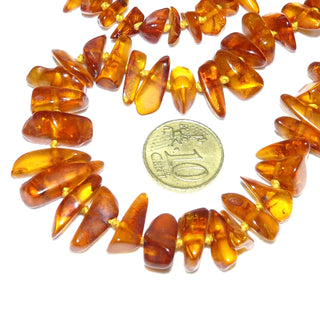 Handgeschliffenes Einzelstück, Vintage-Bernstein-Kette aus polierten, großen, länglichen Chips / Splittern, im Verlauf durchgeknotet, mittleres Cognac-orange, Verschluß aus Gold-Doublé, Gesamtlänge 56 cm, um 1950 -	Vintage-Schmuck nur im Onlineshop von danilogold!