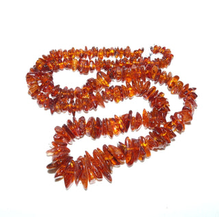 handgefädeltes Einzelstück, Vintage-Bernstein-Kette aus polierten gerundeten Splittern, im Verlauf ungeknotet aufgereiht, leuchtendes mittleres Cognac-orange, ohne Verschluß, Gesamtlänge 70 cm, um 1970 -	Handgefertigter Schmuck nur erhältlich bei www.danilogold-shop.de 