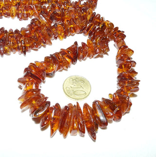 handgefädeltes Einzelstück, Vintage-Bernstein-Kette aus polierten gerundeten Splittern, im Verlauf ungeknotet aufgereiht, leuchtendes mittleres Cognac-orange, ohne Verschluß, Gesamtlänge 70 cm, um 1970 -	Handgefertigter Schmuck nur erhältlich bei www.danilogold-shop.de 
