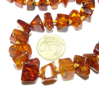 handgefädeltes Einzelstück, Vintage-Bernstein-Kette aus polierten, sparsam facettierten, eckigen Nuggets, im Verlauf durchgeknotet, mittleres Cognac-braun mit schönen Einschlüssen, Verschluß aus Gold-Doublé, Gesamtlänge 58 cm, um 1930 -	Handgefertigtes Unikat! Nur im Onlineshop von Juwelier & Goldschmiede Danilo!