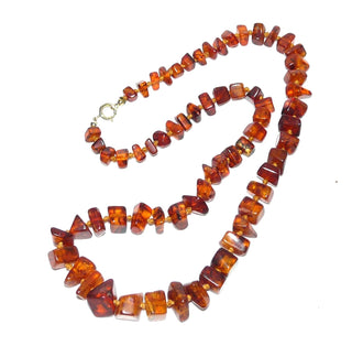 handgefädeltes Einzelstück, Vintage-Bernstein-Kette aus polierten, sparsam facettierten, eckigen Nuggets, im Verlauf durchgeknotet, mittleres Cognac-braun mit schönen Einschlüssen, Verschluß aus Gold-Doublé, Gesamtlänge 58 cm, um 1930 -	Handgefertigtes Unikat! Nur im Onlineshop von Juwelier & Goldschmiede Danilo!