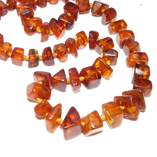 handgefädeltes Einzelstück, Vintage-Bernstein-Kette aus polierten, sparsam facettierten, eckigen Nuggets, im Verlauf durchgeknotet, mittleres Cognac-braun mit schönen Einschlüssen, Verschluß aus Gold-Doublé, Gesamtlänge 58 cm, Art Deco um 1930 - Handgefertigtes Unikat! Nur im Onlineshop von Juwelier & Goldschmiede Danilo!