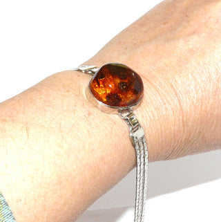 Vintage-Einzelstücke, Bernsteinarmband aus 925 Silber mit einem transparenten honigbraunen leicht ovalen Cabochon mit schönen Linseneinschlüssen in Zargenfassung, 17,5cm lang, Hakenverschluß, Polnisch modernistischer Ostsee-Stil Danzig Ende 1980-er Jahre - Goldschmiede Danilo