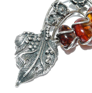 Vintage-Einzelstück, florale Bernsteinbrosche aus 925 Silber, in den Tiefen geschwärzt, cognac rundoval im Größenverlauf mit Linseneinschlüssen, Weinblatt & Rosen, Hakenverschluß, Danziger Silber-Stil um 1965 - Goldschmiede Danilo