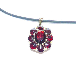 Ovales Einzelstück, Vintage-Granat-Anhänger aus 333 Gold, ovale Rosette bestehend aus 8 runden Steinen im Sternschliff + einem ovalen, facettierten Granat im schönen typischen Rot, in Krappenfassungen gehalten, konischer Kader, Dreieckschlaufe, um 1980 - Goldschmiede-Danilo