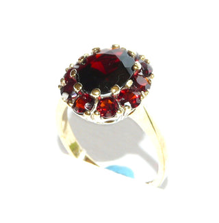 Vintage-Einzelstück, Granatring aus 333 Gold mit einem größeren ovalen & 10 kleineren runden, funkelnd facettierten Böhmischen Granaten in schöner Farbe im Brillantschliff, luftiges Körbchen unter der ovalen Rosette aus Krappenfassungen, Ringweite 56, um 1960 - Goldschmiede Danilo