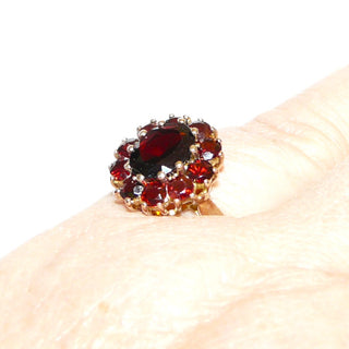 Vintage-Einzelstück, Granatring aus 333 Gold mit einem breitovalen & 10 kleineren runden, facettierten Böhmischen Granaten im Altschliff, ovale Rosette mit einem Drahtkörbchen als Fingerauflage, Cocktailring, Krappenfassungen, Ringweite 58,5, um 1960 - Goldschmiede Danilo