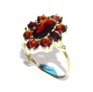 Vintage-Einzelstück, Granatring aus 333 Gold mit einem langovalen & 8 runden, funkelnd facettierten Granate in schöner Farbe, ovale Rosette in Krappenfassungen, 2 Kügelchen als Übergang zur Ringschiene, Ringweite 54,5, um 1960, Friedrich Hutte Pforzheim - Goldschmiede Danilo